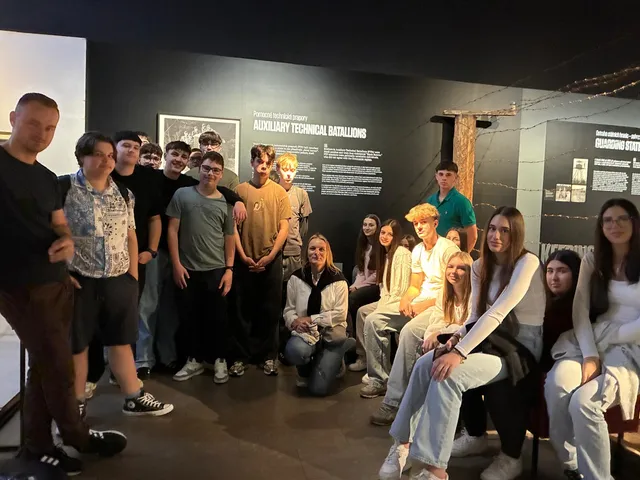 Die Gruppe im Museum des Kommunismus in Prag vor einer Ausstellungstafel zu den Hilfstechnischen Bataillonen.